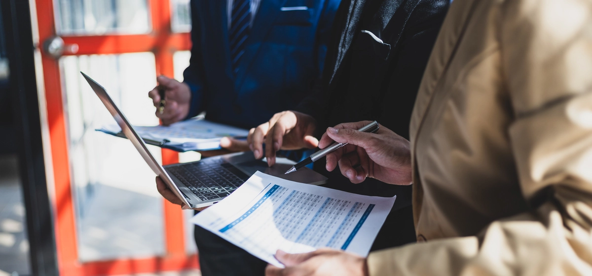 Deux hommes en train de discuter avec des papiers à la main